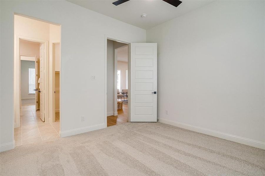 Unfurnished bedroom featuring light colored carpet and ceiling fan