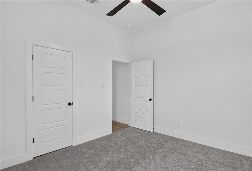 Spacious room featuring vaulted ceilings, a ceiling fan with integrated lighting, and light grey carpeting Spacious room featuring vaulted ceilings, a ceiling fan with integrated lighting, and light grey carpeting