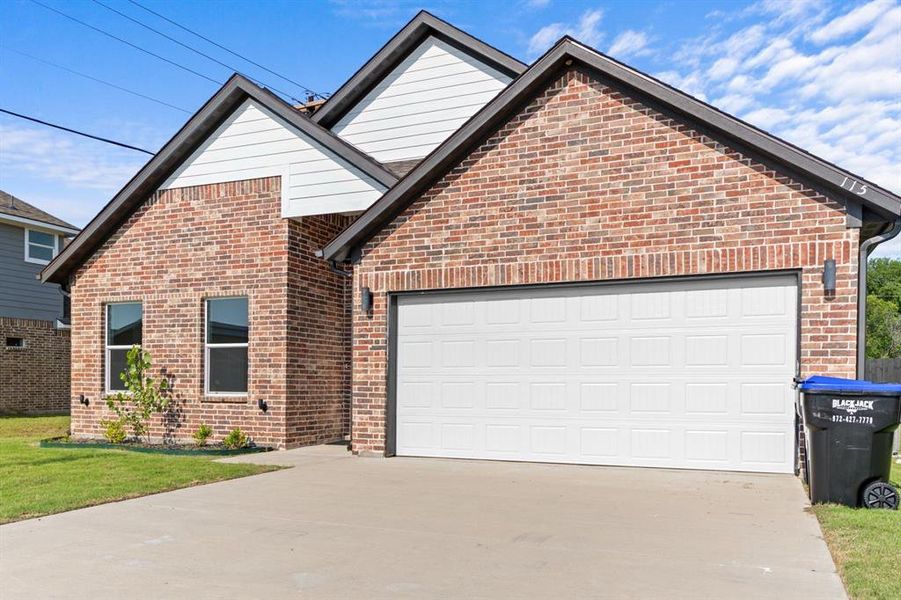 View of front of home featuring driveway, brick siding, and a garage View of front of home featuring driveway, brick siding, and a garage