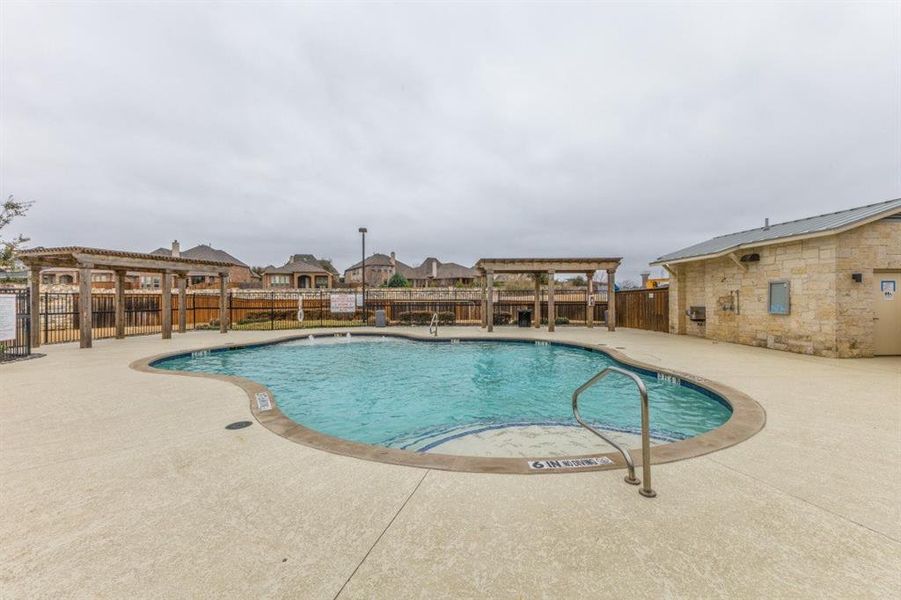 Community pool featuring a patio, a pergola, and a fenced backyard