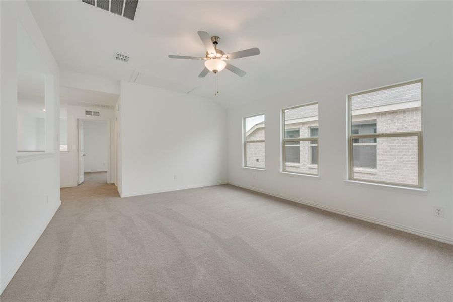 Carpeted empty room featuring ceiling fan