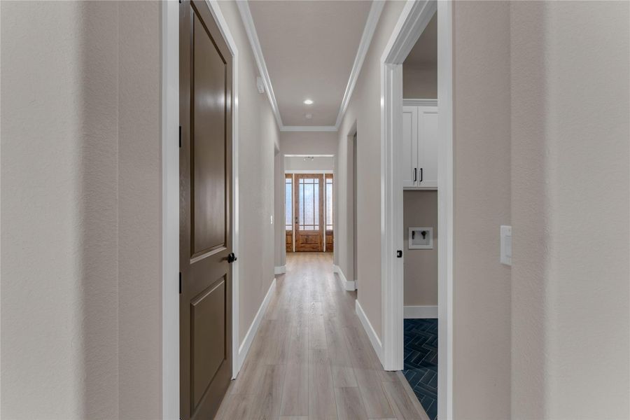 Hallway with ornamental molding, light wood finished floors, and recessed lighting