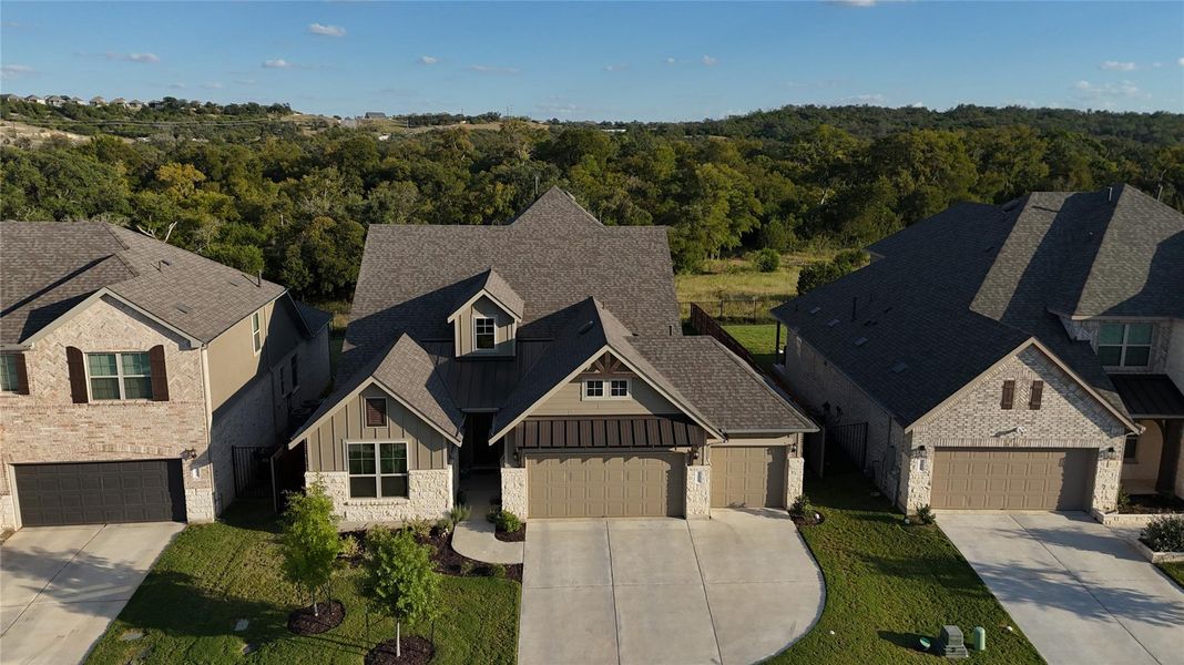 View of front of property with board and batten siding, a garage, stone siding, a standing seam roof, and concrete driveway View of front of property with board and batten siding, a garage, stone siding, a standing seam roof, and concrete driveway