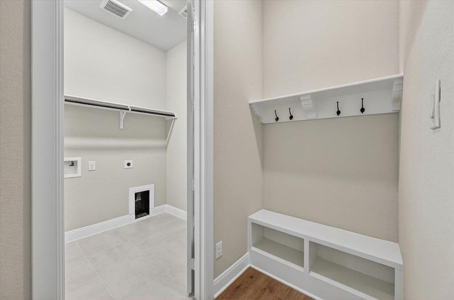 Dedicated laundry room featuring tile flooring, upper shelving, and connections for appliances Dedicated laundry room featuring tile flooring, upper shelving, and connections for appliances