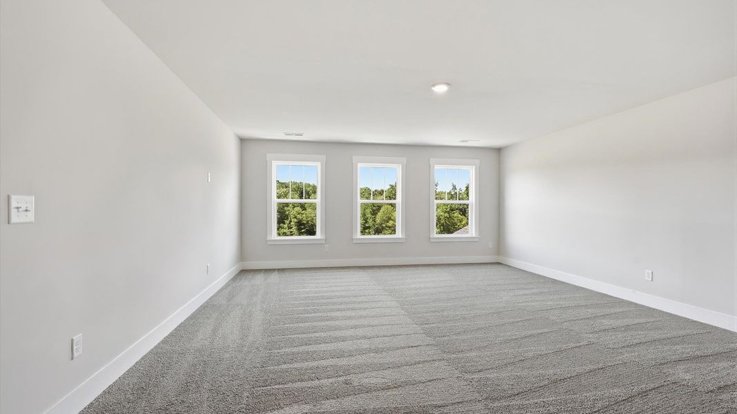 Spacious bedroom with generous proportions, a walk-in closet, and beautiful natural light through large windows at Pinebrook