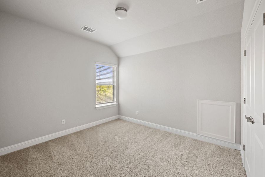 Carpeted spare room with baseboards, visible vents, and vaulted ceiling Carpeted spare room with baseboards, visible vents, and vaulted ceiling