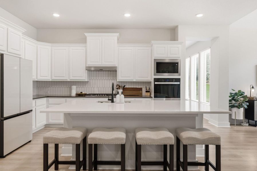 The expansive breakfast bar offers the perfect spot for casual morning coffee, quick homework sessions, or chatting with the chef while dinner is being prepped