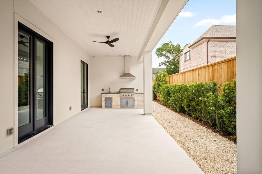 Expansive covered patio featuring a built-in outdoor kitchen and seamless indoor-outdoor flow.