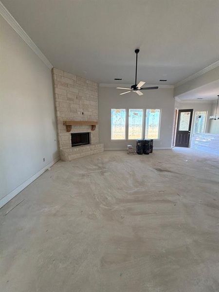 Unfurnished living room featuring ornamental molding, a fireplace, ceiling fan, and concrete flooring