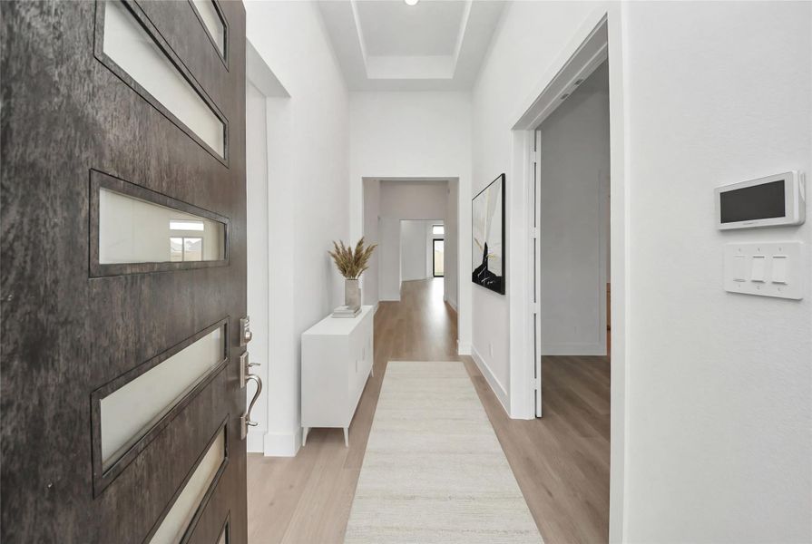 An inviting entrance opens up to an open-concept layout, seamlessly connecting the entry to the study and Great Room with durable laminate flooring and striking architectural details. An inviting entrance opens up to an open-concept layout, seamlessly connecting the entry to the study and Great Room with durable laminate flooring and striking architectural details.