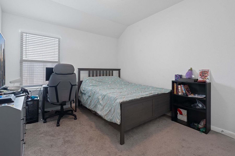 Bedroom featuring vaulted ceiling, light colored carpet, and a desk Bedroom featuring vaulted ceiling, light colored carpet, and a desk