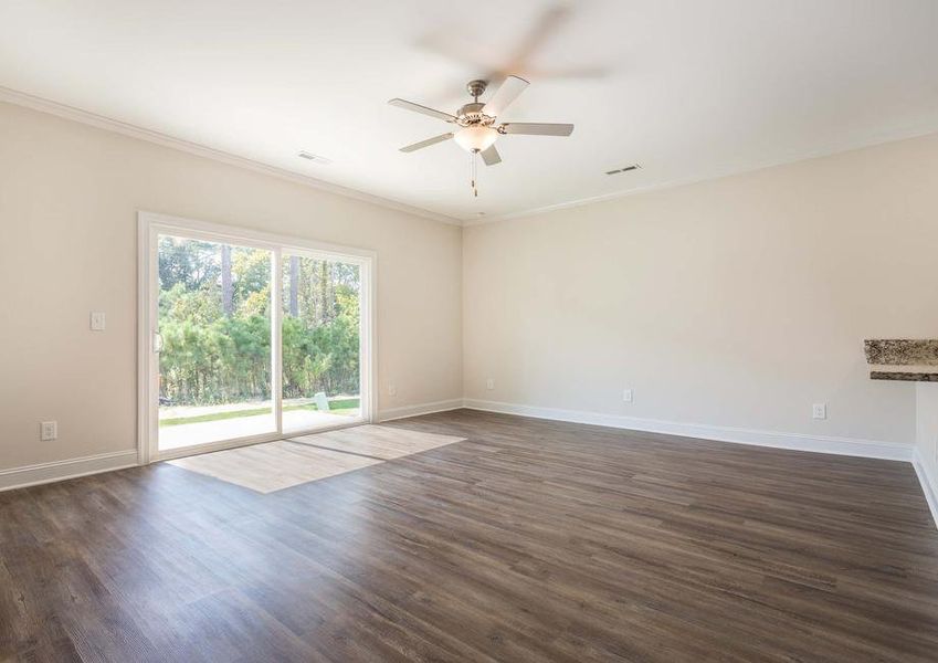 Living room with vinyl flooring, a ceiling fan and a sliding glass door.