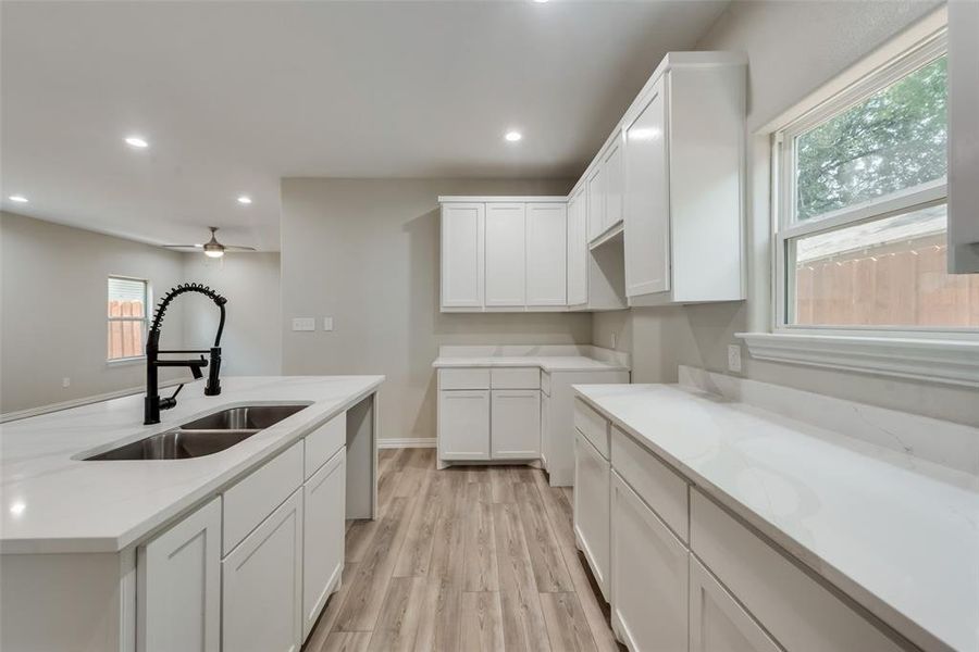 Kitchen featuring plenty of natural light, sink, light wood-type flooring, and ceiling fan