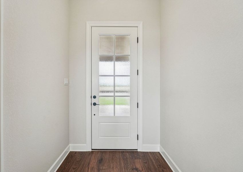 Foyer entry featuring the front door with glass panel and wood-look vinyl flooring. Foyer entry featuring the front door with glass panel and wood-look vinyl flooring.