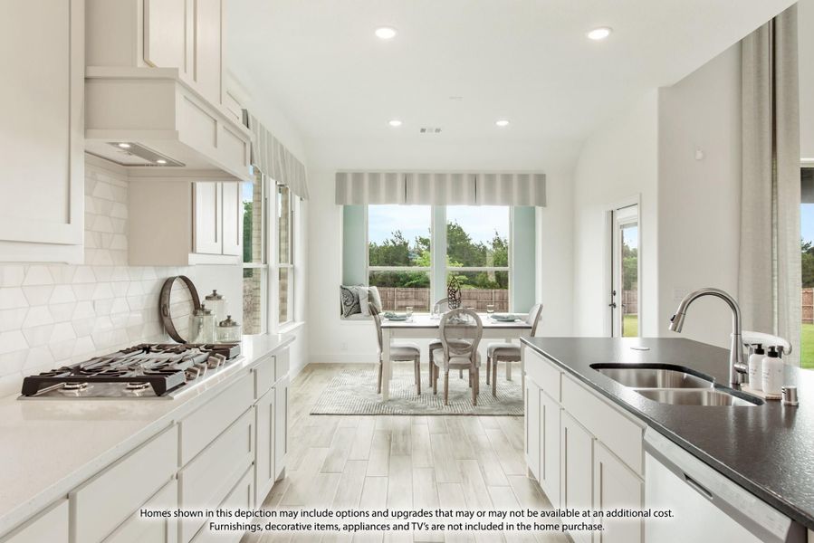 White kitchen with gas cooktop, dark countertop island, and open view to breakfast nook with large windows