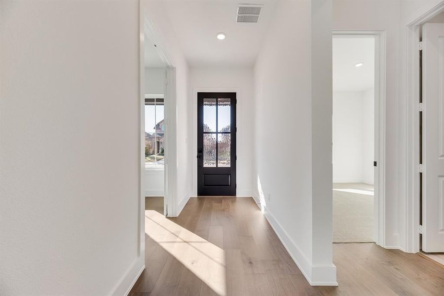 Foyer entrance featuring light wood finished floors and recessed lighting