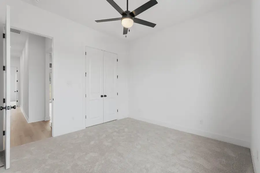 Spacious secondary bedroom with neutral finishes and flexibility for guests, office, or hobbies.