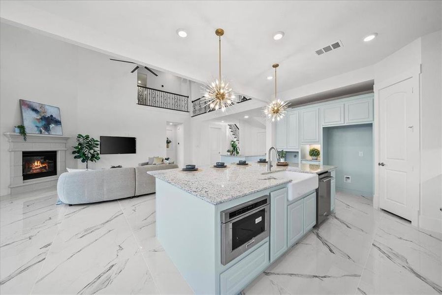 Kitchen featuring custom cabinetry, quartz counters, recessed lighting, open floor plan, decorative light fixtures Kitchen featuring custom cabinetry, quartz counters, recessed lighting, open floor plan, decorative light fixtures