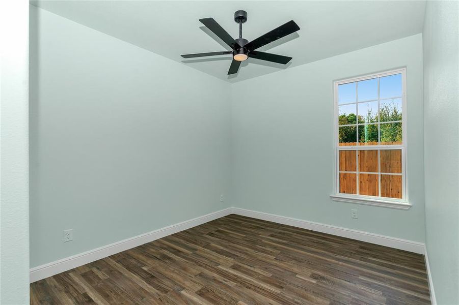 Unfurnished room with dark wood-style floors and ceiling fan