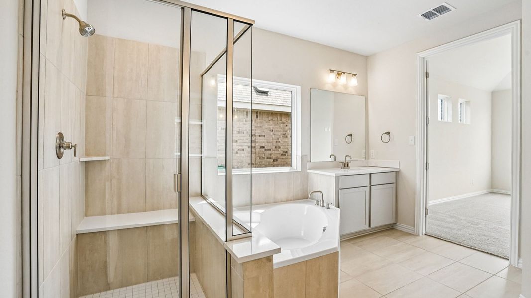 Luxurious Owner's Bath with Garden Tub, Glass Enclosed Shower, and Separate Vanities