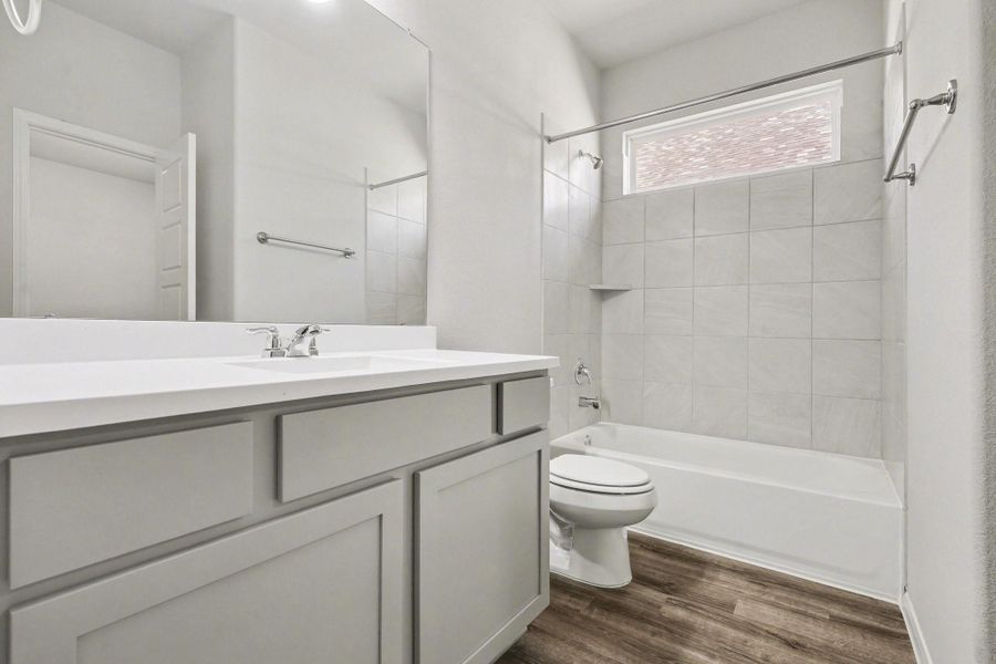 Clean and bright guest bath with tile surround and modern fixtures Clean and bright guest bath with tile surround and modern fixtures