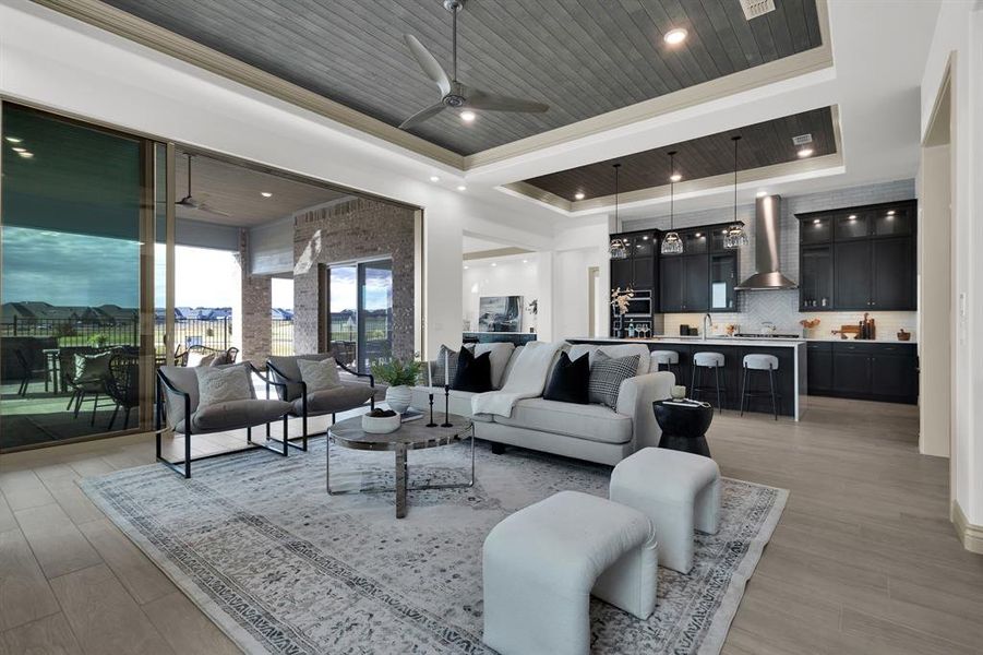 Living room with light wood-style flooring, wood ceiling, a ceiling fan, recessed lighting, and a tray ceiling
