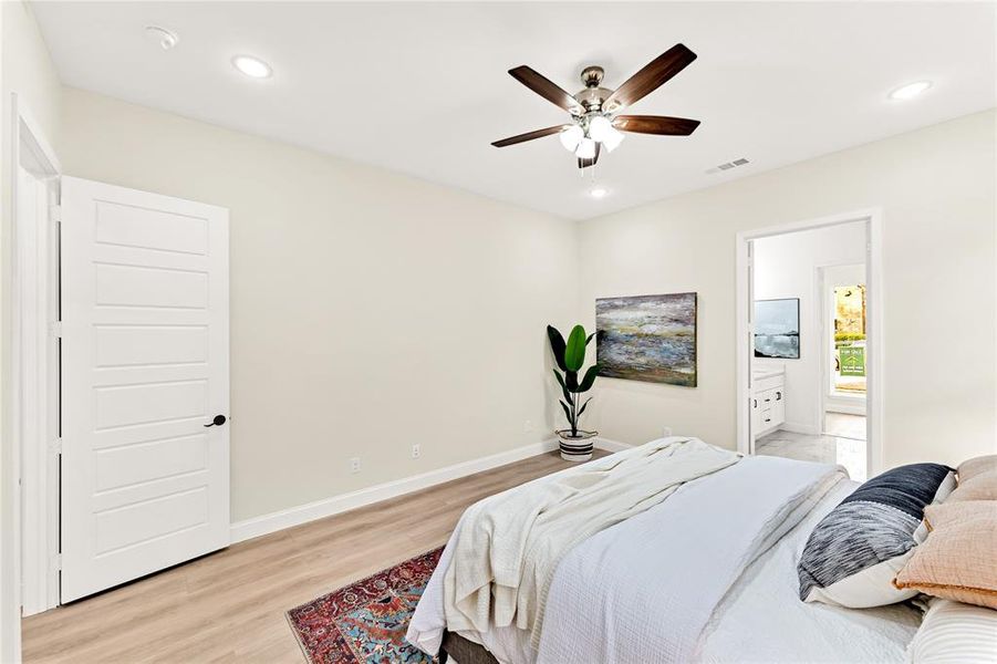 Bedroom featuring connected bathroom, ceiling fan, and light wood-type flooring