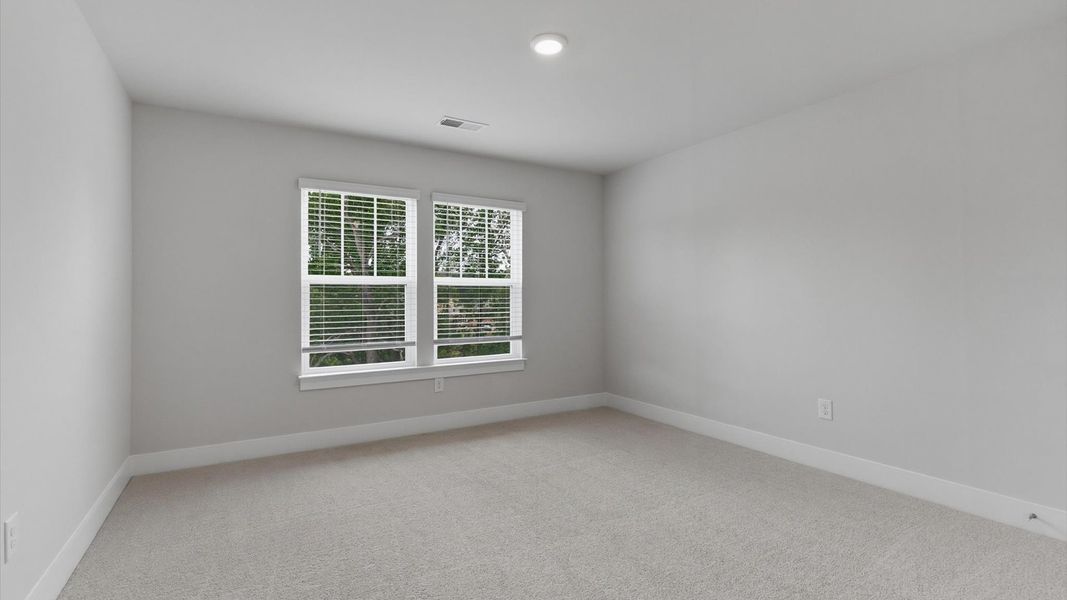 Inviting bedroom with tasteful finishes and large windows that create a fresh, open ambiance at Village at Midway Inviting bedroom with tasteful finishes and large windows that create a fresh, open ambiance at Village at Midway