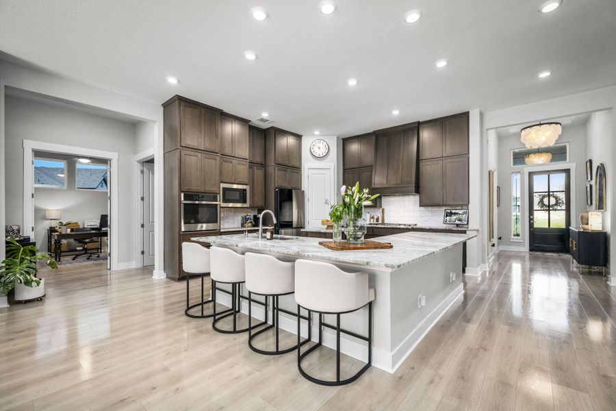 A chef's kitchen boasts a generous island with seating, ideal for entertaining and daily living.