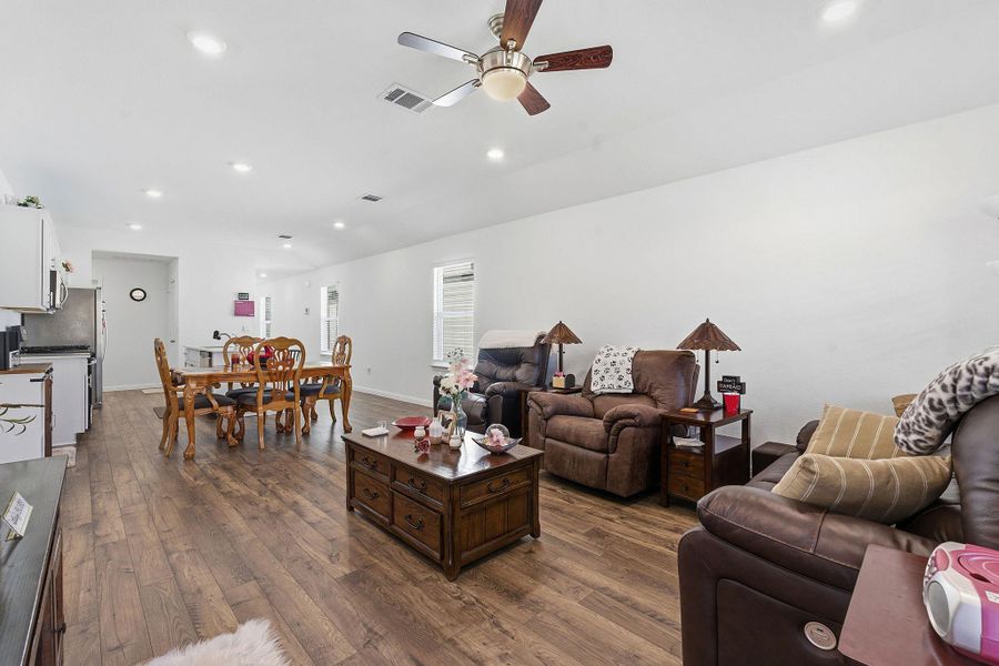 Living area featuring dark wood-style floors, recessed lighting, vaulted ceiling, and a ceiling fan