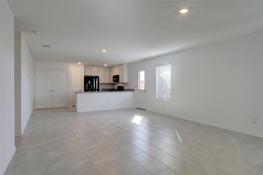 Unfurnished living room with light tile patterned flooring and recessed lighting