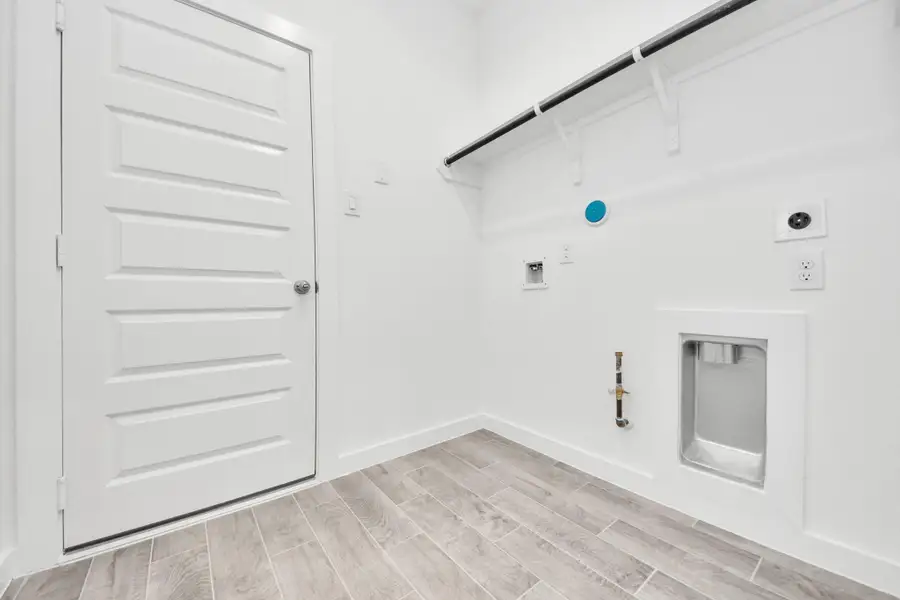 A perfect blend of functionality and comfort. Capture the essence of easy living with a first-floor laundry room, thoughtfully equipped with shelving for effortless organization. Both electric and gas connections available. Sample photo of completed home with similar floor plan. Actual colors and selections may vary. A perfect blend of functionality and comfort. Capture the essence of easy living with a first-floor laundry room, thoughtfully equipped with shelving for effortless organization. Both electric and gas connections available. Sample photo of completed home with similar floor plan. Actual colors and selections may vary.