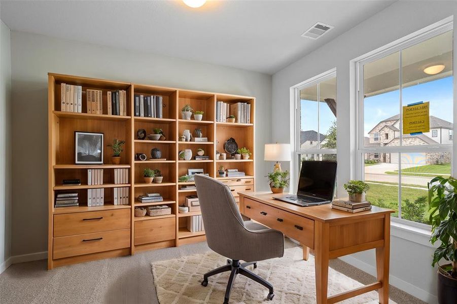 Quietly nestled in front of the home is the handsome home office. Featuring plush carpet, high ceilings, large windows with privacy blinds and custom paint.