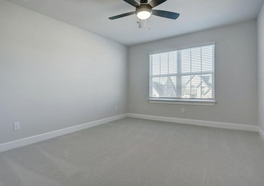 Secondary bedroom with large windows and a ceiling fan.