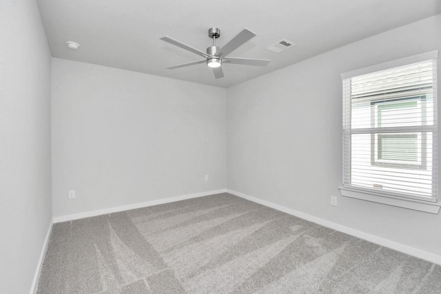 Secondary bedroom features plush carpeting, large windows that let in plenty of natural light, bright paint, and spacious closets. Sample photo of completed home with similar floor plan. Actual colors and selections may vary.