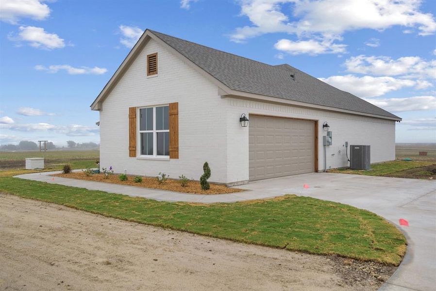 View of home's exterior with a garage and central AC