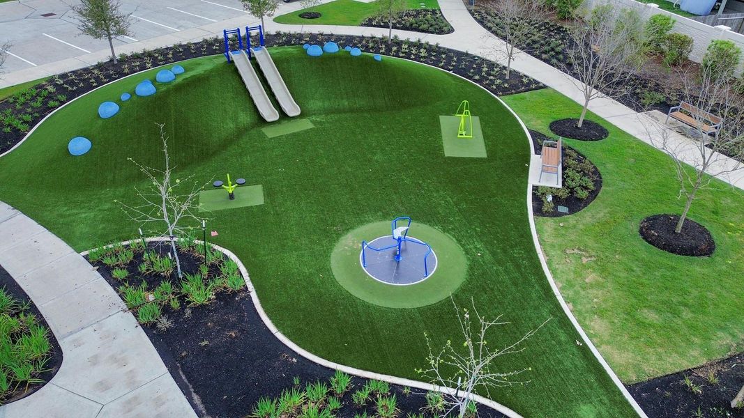Thoughtfully designed playground area featuring slides, interactive play equipment, and soft turf surfaces, creating a fun and safe space for kids to enjoy within the neighborhood park.