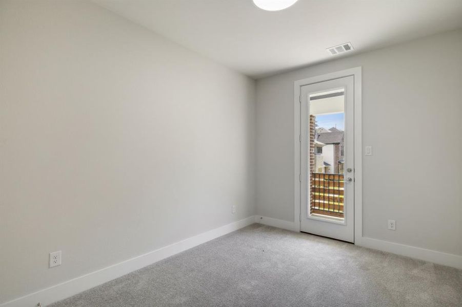 secondary bedroom featuring plenty of natural light, visible vents, baseboards, and light colored carpet