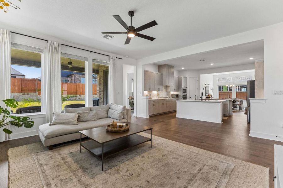 Rich hardwood floors anchor this open concept layout connecting the main living area and kitchen.