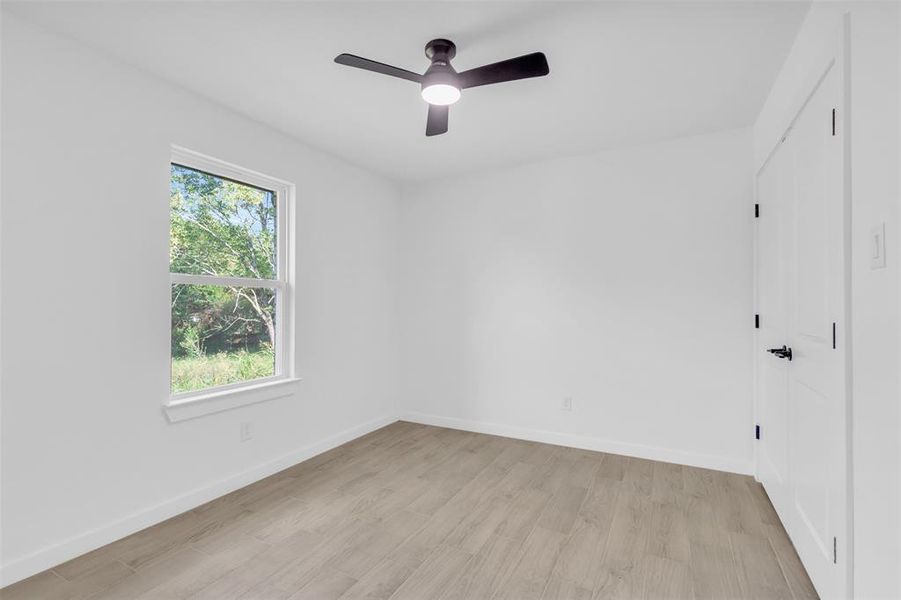 Unfurnished room with light wood finished floors and a ceiling fan