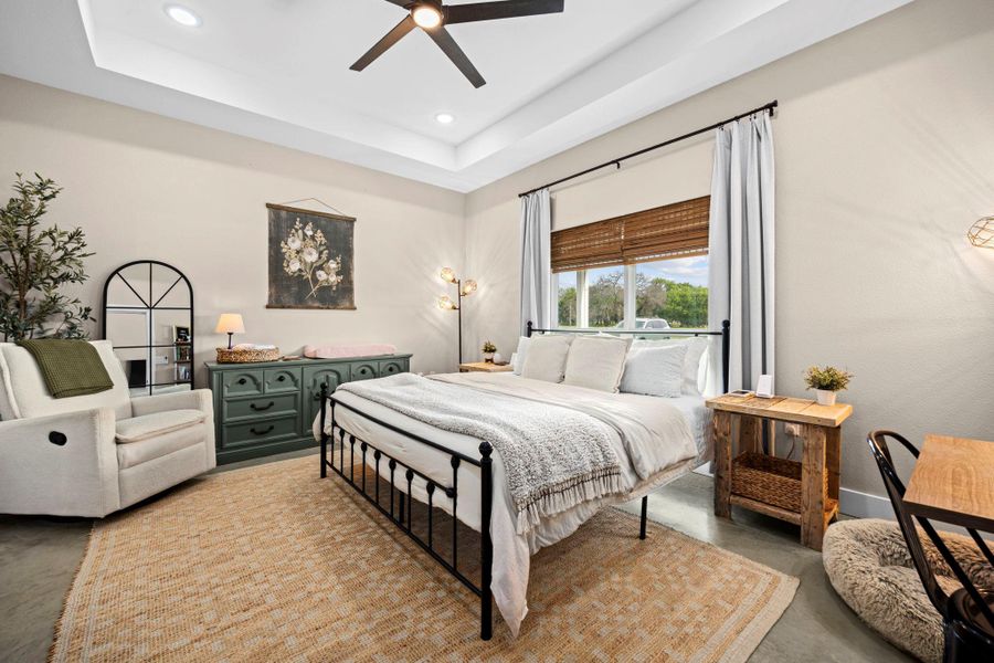 Bedroom featuring finished concrete floors, a ceiling fan, recessed lighting, and a raised ceiling