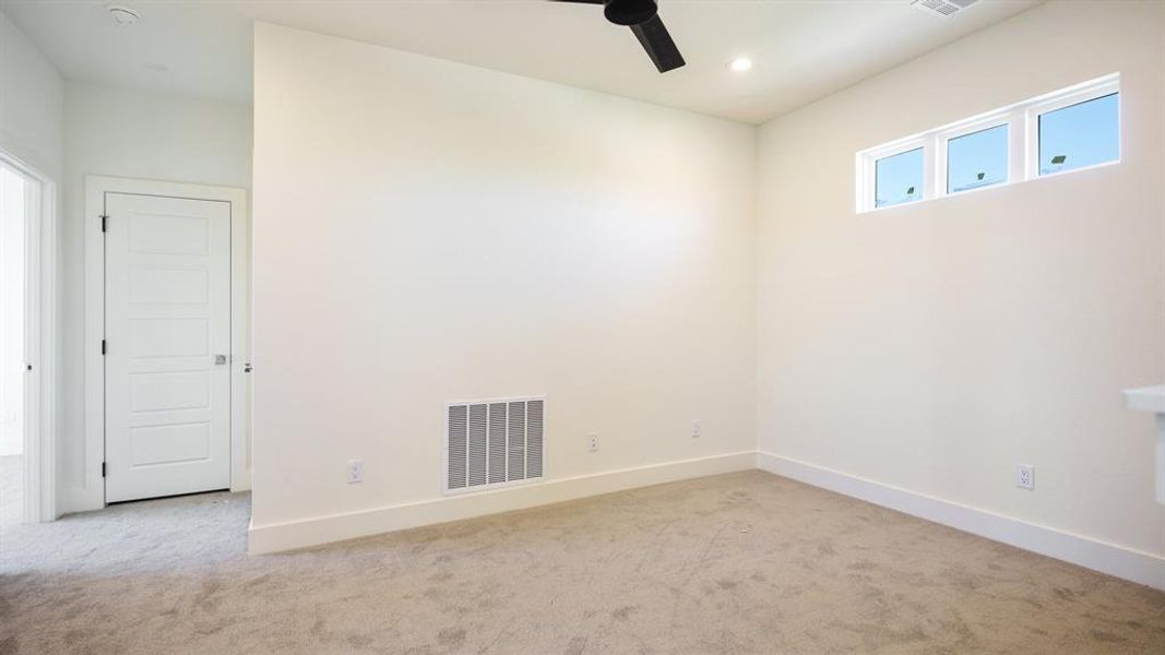 Spare room featuring light colored carpet and ceiling fan