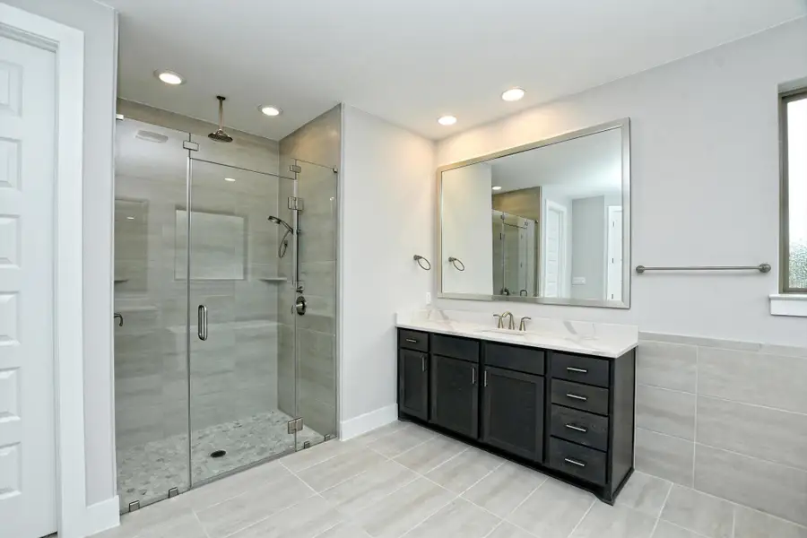 Bathroom featuring tile patterned floors, vanity, a stall shower, and recessed lighting