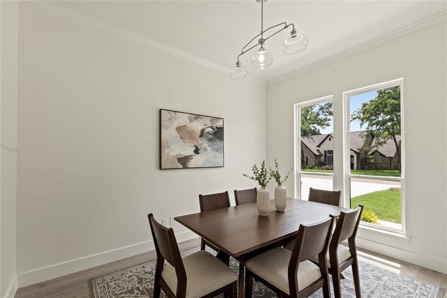 Dining space featuring crown molding, baseboards, and wood finished floors