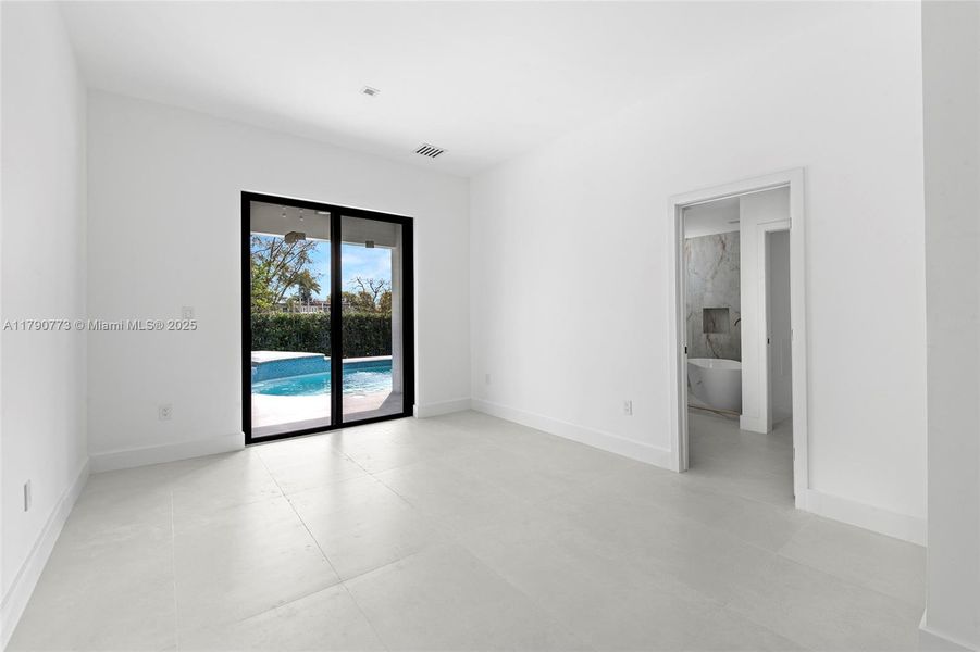 The elegant primary bedroom flows out to the secluded backyard retreat, where a free-form pool and heated sauna await. The elegant primary bedroom flows out to the secluded backyard retreat, where a free-form pool and heated sauna await.