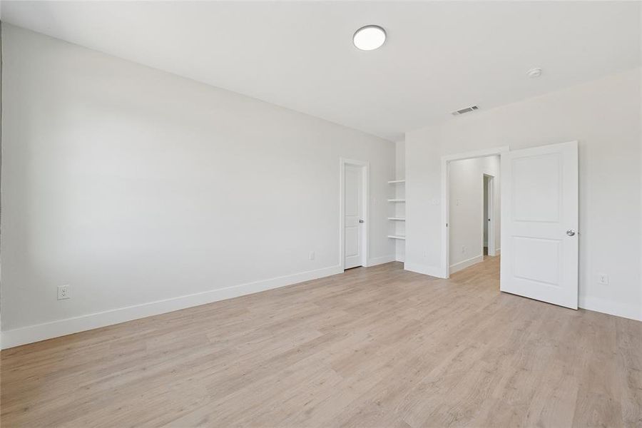 Spare room with light wood-type flooring and baseboards