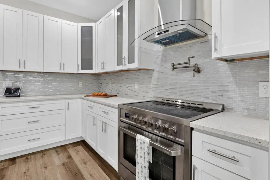 Closer look at never been used stainless steel stove 36"inch, custom backsplash, and plenty of counter space and storage cabinets.