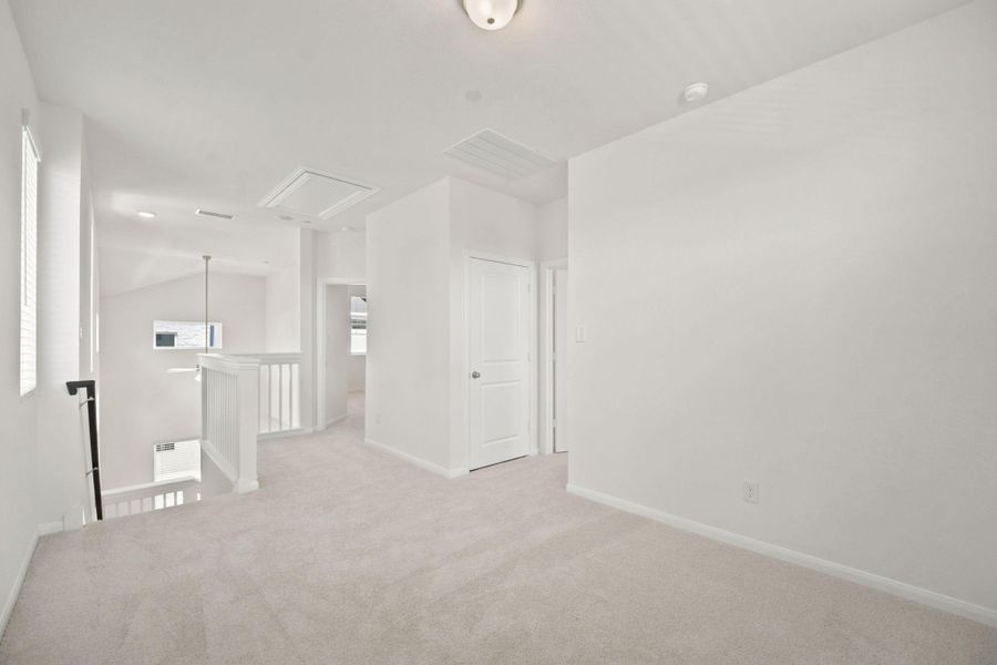 A spacious upper-level landing features soft carpeting, recessed details, and access to nearby rooms.