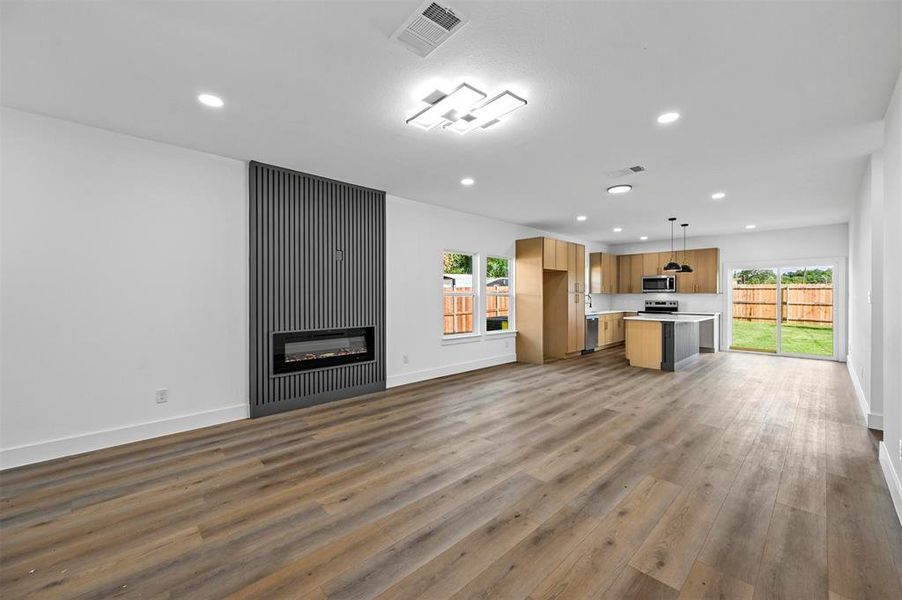 Unfurnished living room with hardwood / wood-style floors and a large fireplace