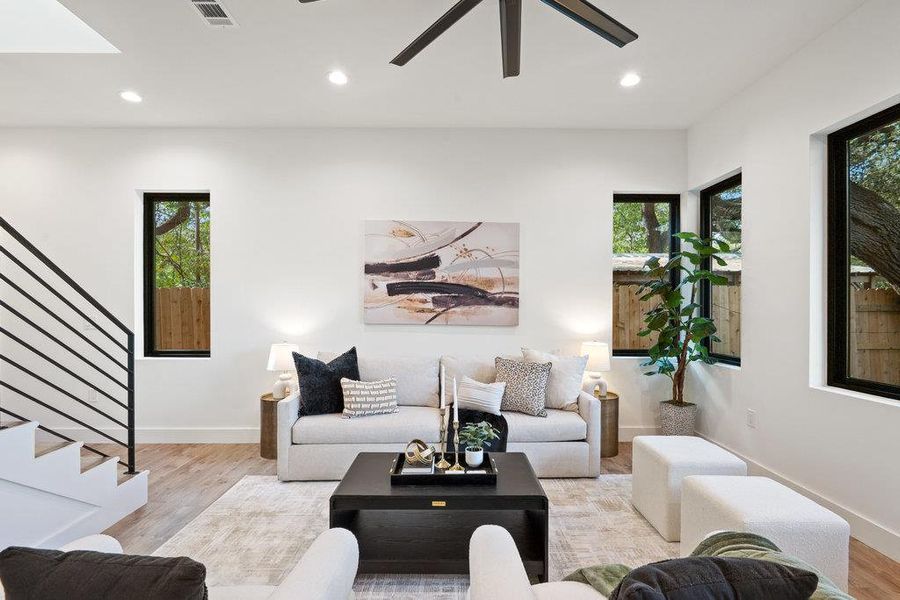Living area featuring wood finished floors, recessed lighting, stairway, and ceiling fan